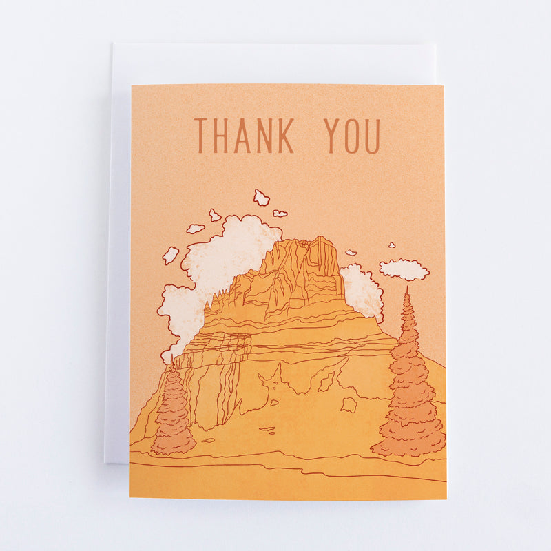 An orange card with a bright orange mountain that has white clouds behind in and dark orange trees in front. The text above reads Thank You.
