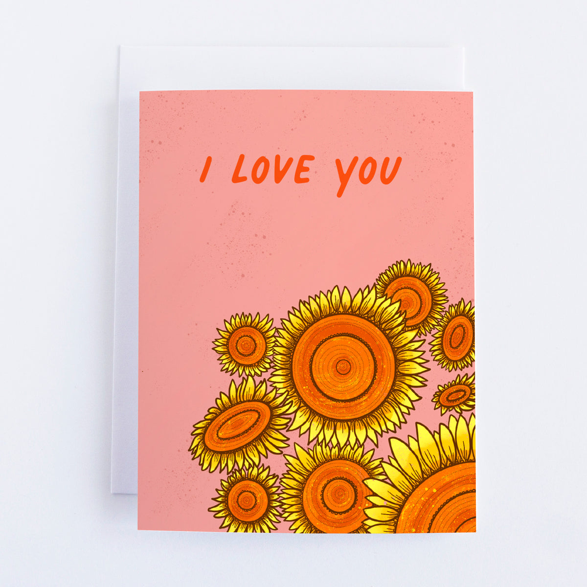 A pink greeting card with 9 sunflowers in the bottom right quadrant and I Love You in the top half of the card.
